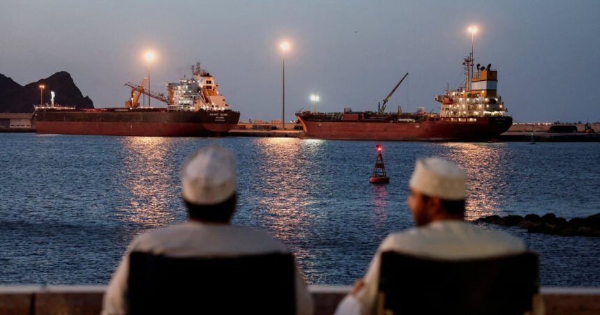 مواطنان عُمانيان جالسان أمام ناقلات في مضيق هرمز